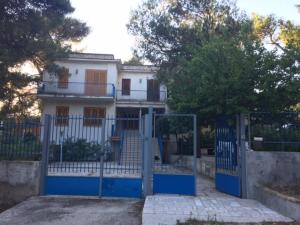 a blue gate in front of a white house at Villa Le Rose in San Menaio