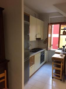 a kitchen with white cabinets and a stainless steel refrigerator at Villa Le Rose in San Menaio