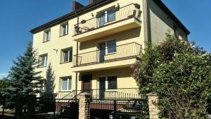 a tall yellow building with a balcony on it at Poilsis Palangoje pas Daivą in Palanga