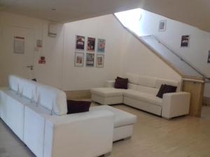 a living room with white furniture and a staircase at The Britannia Nottingham Hotel in Nottingham