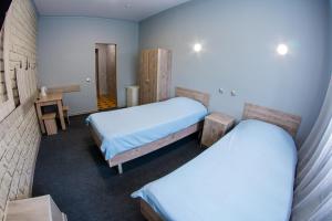 een kleine kamer met 2 bedden en een bureau bij Tri Peskarya Hotel in Koersk