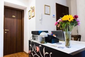 a desk with a vase of flowers on it at Domus Popolo in Rome
