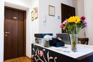 Un escritorio con un jarrón de flores. en Domus Popolo, en Roma