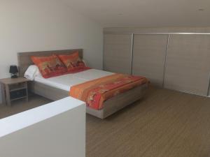 um quarto com uma cama com almofadas laranja em Au bon logis Luberon 50m2 em Cheval-Blanc