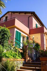 a house with green shutters and stairs in front at Hotel La Margherita in Diano Marina