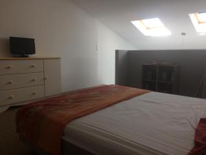 um quarto com uma cama e uma cómoda com uma televisão em Au bon logis Luberon 50m2 em Cheval-Blanc