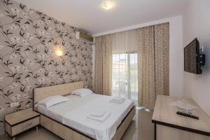 - une chambre avec un lit et un mur orné d'un motif d'oiseaux dans l'établissement Lucas, à Costinesti