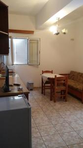 a kitchen and living room with a table and a couch at Elena Apartament in Sarandë +28 photos