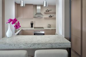 a kitchen with a table with purple flowers in a vase at Hyatt Regency Creek Heights Residences in Dubai