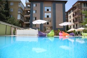 uma grande piscina com cadeiras insufláveis coloridas e guarda-sóis em King Hotel Guvenlik em Ancara