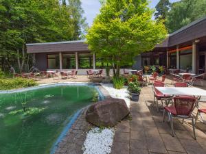 a patio area with tables, chairs, and a pool at DORMERO Hotel Freudenstadt in Freudenstadt