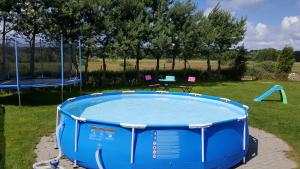a blue pool with a table and a swing at Bajeczne domki in Ustka