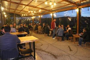 a group of people sitting at tables in a restaurant at Zeytindalı Yayla Hotel in Hackali Baba Yaylasi