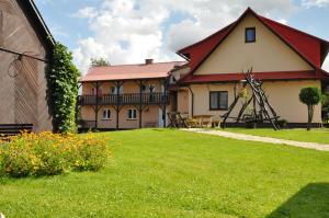 a house with a red roof and a grass yard at Nad Krolówką in Ustrzyki Dolne