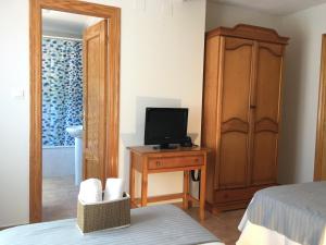 a bedroom with a bed and a tv on a table at Hostal El Paso in Beranga