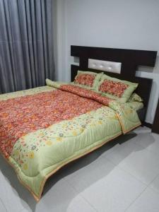 Un dormitorio con una cama grande con flores. en Green Valley Apartments en Bhurban