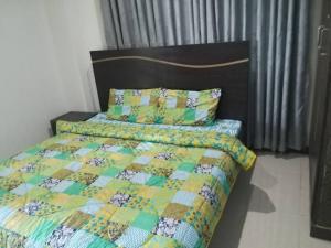 a bed with a quilt and two pillows on it at Green Valley Apartments in Bhurban