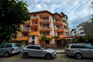 two cars parked in front of a building at Primorski Briz Guest House in Primorsko