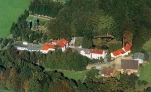 eine Luftansicht eines Hauses auf einem Berg in der Unterkunft Moorland Hotel am Senkelteich in Vlotho