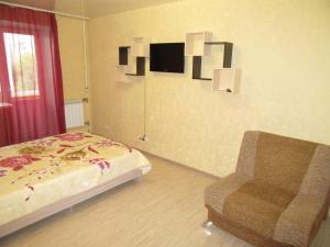 ペルミにあるApartments on Lenina 72Bのベッドルーム1室(ベッド1台、椅子付)
