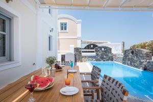 a dining room with a table and a swimming pool at Secret Earth Villas - Santorini in Kamari