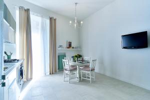 ナポリにあるla marcellinaの白いキッチン(テーブル、椅子、テレビ付)