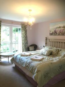 a bedroom with a large bed and a chandelier at The Waterwheel in St Austell