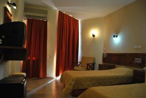 En eller flere senger på et rom på Benna Hotel