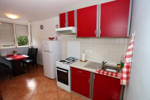 a small kitchen with red cabinets and a sink at Apartment Marko 1 in Split