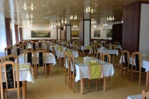 a dining room with white tables and chairs at OSW Kaper in Jurata