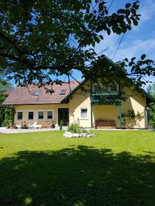 una casa con un césped verde delante de ella en Landhaus HALLSTATT FEELING - Apartment - Self Check-in, en Bad Goisern