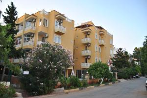 a yellow apartment building on the side of a street at Benna Hotel in Antalya