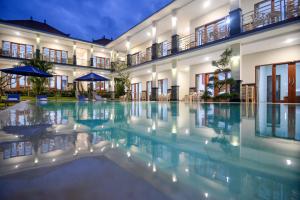 a swimming pool in front of a building at Pondok Canggu Homestay in Canggu