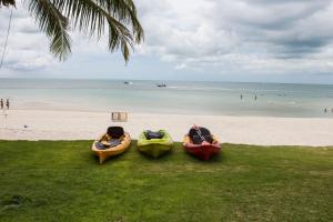 three kayaks on a beach with the ocean in the background at Tommy Resort in Haad Rin