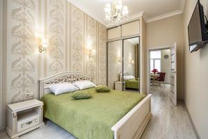 een slaapkamer met een groen bed en een spiegel bij American Apartment in Lviv