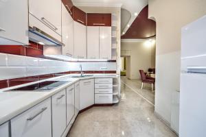 eine Küche mit weißen Schränken und einem Waschbecken in der Unterkunft American Apartment in Lwiw