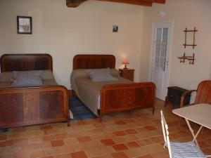 a bedroom with two beds and a cross on the wall at Domaine les Galards in Le Garde