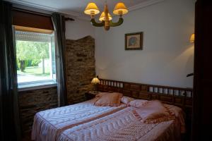 a bedroom with a large bed with a window at Casa Gayol in El Franco