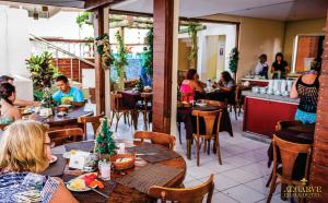 a group of people sitting at tables in a restaurant at Algarve Praia Hotel in Fortaleza