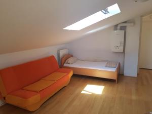 a living room with a couch and a bed at Peachy House in Rijeka