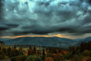 a cloudy sky with trees and mountains in the distance at u Wilczka in Zwardoń