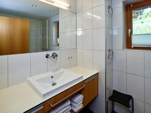 a white bathroom with a sink and a mirror at Montafon Chalets in Gaschurn