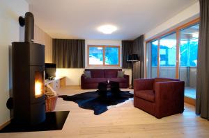 sala de estar con sofá y chimenea en Montafon Chalets, en Gaschurn