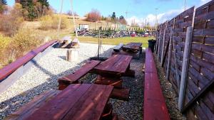 a group of wooden benches sitting next to a fence at u Wilczka in Zwardoń +2 photos