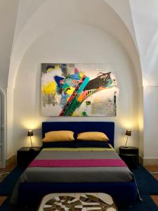a bedroom with a bed with a painting on the wall at ART TO DESIGN B&B in Lecce