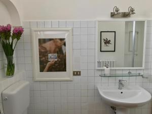 a bathroom with a sink and a vase of flowers at ART TO DESIGN B&B in Lecce