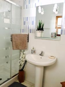 a white bathroom with a sink and a shower at La Santa Feel Good in La Santa +11 photos