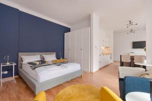 1 dormitorio con cama y pared azul en Imperial Apartments - Classic by Hampton en Sopot