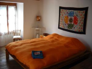 ein Schlafzimmer mit einem Bett mit einer orangefarbenen Decke in der Unterkunft Guesthouse By Wild in Linescio