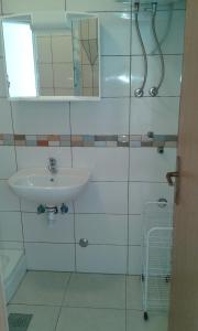 a white bathroom with a sink and a mirror at Apartmani Jelena in Podgora +22 photos